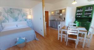 a bedroom with a bed and a table and a kitchen at Il Portico Rosa in Cuglieri