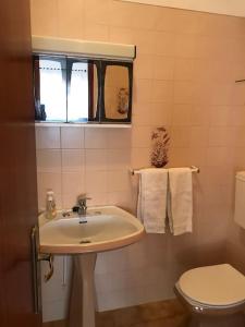 a bathroom with a sink and a toilet and a window at A Terraza da Filipa in Vila Praia de Âncora