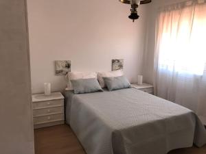 ein weißes Schlafzimmer mit einem Bett und einem Fenster in der Unterkunft A Terraza da Filipa in Vila Praia de Âncora