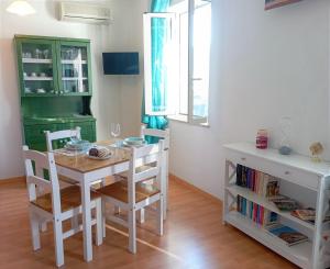 a dining room with a white table and chairs at Il Portico Rosa in Cuglieri
