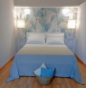 um quarto com uma cama grande com lençóis e almofadas azuis em Il Portico Rosa em Cuglieri