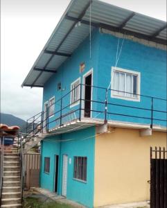a blue house with a balcony and stairs at Espaço Alto da Colina em Penedo RJ in Itatiaia