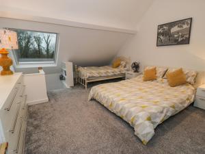 a bedroom with a bed and a desk and a window at Bronwen House in Llanbedr