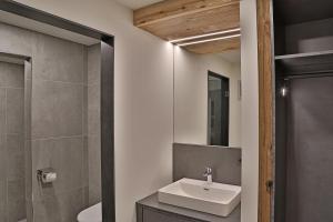 een badkamer met een witte wastafel en een douche bij Sieglhub Chalets - Appartements - Hotel in Flachau