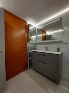 a kitchen with a sink and a wooden door at Eolia apartment with panoramic Chania view in Chania Town