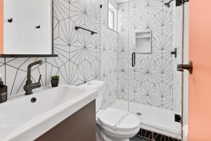 a bathroom with a white toilet and a shower at 5BR Beach Block Orange Loop Steps from Boardwalk in Atlantic City +37 photos
