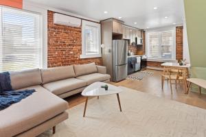 a living room with a couch and a brick wall at 5BR Beach Block Orange Loop Steps from Boardwalk in Atlantic City