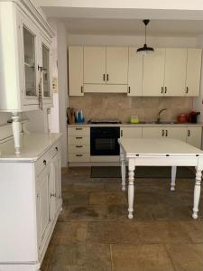 cocina con armarios blancos y mesa blanca en Villa Delfino, en San Foca