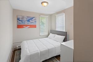 um quarto branco com uma cama branca e um quadro em 5BR Beach Block Orange Loop Steps from Boardwalk em Atlantic City