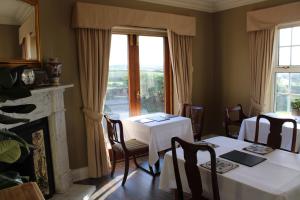 a dining room with two tables and a fireplace at Carnalbanagh House in Portstewart