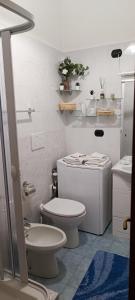 een witte badkamer met een toilet en een wastafel bij La casa di Paolo 2 a Milano in Milaan