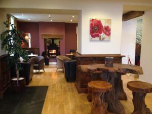 a salon with wooden tables and stools in a room at Aberdunant Hall in Porthmadog