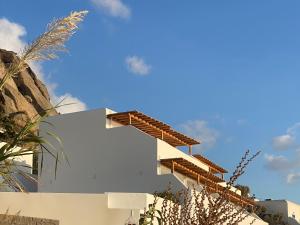 un bâtiment blanc avec un ciel bleu en arrière-plan dans l'établissement Calistus Mykonos, à Mykonos