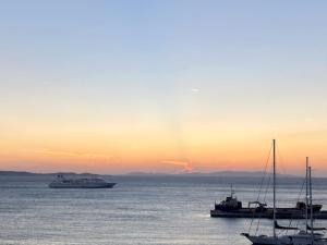 two boats in the water at sunset at Calistus Mykonos in Mikonos