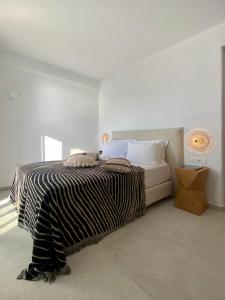 a bedroom with a bed with a black and white blanket at Calistus Mykonos in Mikonos