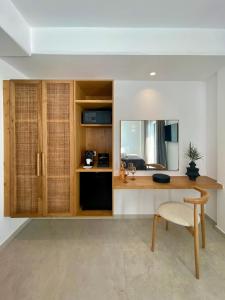 a room with a desk with a chair and a mirror at Calistus Mykonos in Mýkonos City