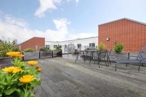 a deck with a table and chairs and flowers at Tower Bridge Lux-Penthouse in London