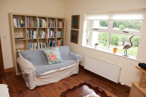 a living room with a couch and a book shelf at The River House in Slane