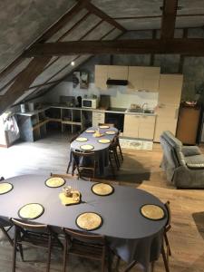 un gruppo di tavoli in una stanza con cucina di La Grange Aux Fleurs a Rigny-la-Nonneuse