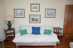 a living room with a white couch with two blue pillows at The River House in Slane