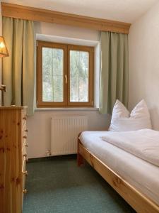 1 dormitorio con 2 camas y ventana en Haus Brandhofer, en Häselgehr