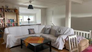 a living room with a white couch and a table at Manus Ferienwohnung in Brevik