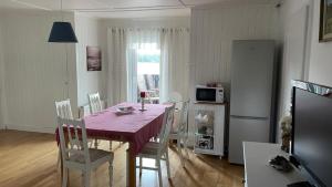 comedor con mesa, sillas y microondas en Manus Ferienwohnung, en Brevik