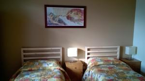 a bedroom with two beds and a picture on the wall at B&B Patty's House in Adrano +25 photos