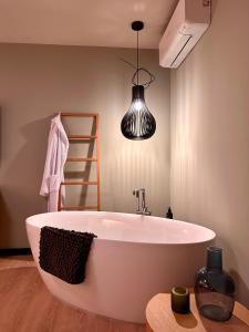 uma grande banheira branca na casa de banho com um candeeiro em Better Living em Obertshausen