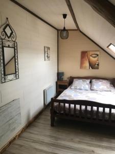 ein Schlafzimmer mit einem Bett im Dachgeschoss in der Unterkunft La Grange Aux Fleurs in Rigny-la-Nonneuse