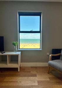 ein Fenster im Wohnzimmer mit Blick auf den Strand in der Unterkunft Margate Beach Front Apt With Sea Views Sleeps 6 in Kent