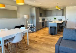 KentにあるMargate Beach Front Apt With Sea Views Sleeps 6のキッチン、リビングルーム(白いテーブル、椅子付)