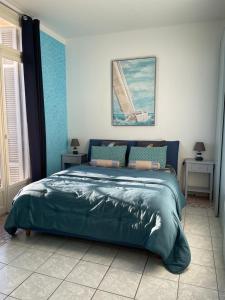 a bedroom with a large green bed in it at Menton centre Vue imprenable sur mer et jardin Biovès in Menton