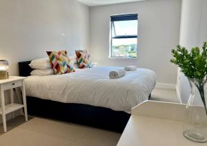 a white bedroom with a bed with towels on it at Margate Beach Front Apt With Sea Views Sleeps 6 in Kent