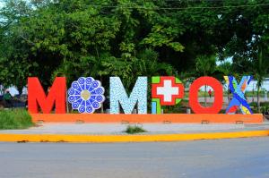 Duży znak z napisem "momo" na boku ulicy. w obiekcie Pueblito Magico Hostel - Mompox w mieście Santa Cruz de Mompox