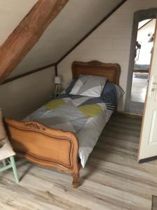 ein Schlafzimmer mit einem großen Bett im Dachgeschoss in der Unterkunft La Grange Aux Fleurs in Rigny-la-Nonneuse