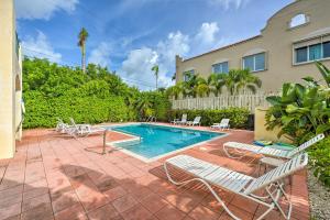 a swimming pool with chairs and a house at Ft Lauderdale Area Condo - Walk to Beach and Shops! in Fort Lauderdale