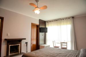 - une chambre avec un lit et un ventilateur de plafond dans l'établissement Hotel Vila Verde, à Nova Petrópolis