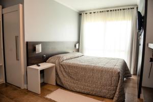 - une petite chambre avec un lit et une fenêtre dans l'établissement Hotel Vila Verde, à Nova Petrópolis