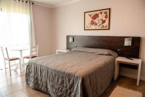 a bedroom with a large bed and a table at Hotel Vila Verde in Nova Petrópolis