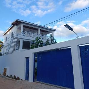 una casa con un garaje azul delante de ella en Doña Mayra Aparta Hotel, en Las Terrenas