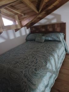 1 cama en un dormitorio con techo de madera en Doña Mayra Aparta Hotel, en Las Terrenas