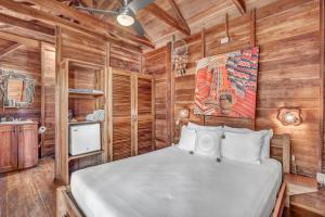 um quarto com uma cama num chalé de madeira em The Beach Bungalows - Yoga and Surf House - Adults Only em Tamarindo