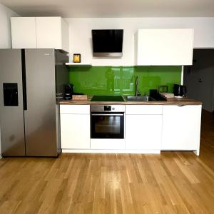 a kitchen with white cabinets and a stainless steel refrigerator at Spacious apartment with terrace in Vienna