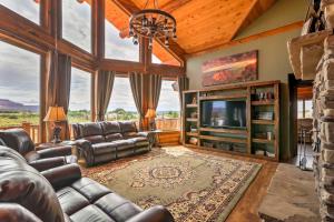 a living room with leather furniture and a tv at Dreamy Kanab Cabin with Hot Tub and Panoramic Views! in Kanab