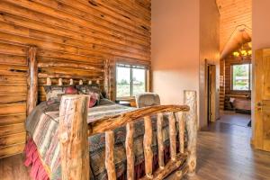 a log cabin bedroom with a bed and wooden walls at Dreamy Kanab Cabin with Hot Tub and Panoramic Views! in Kanab