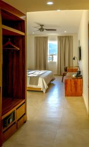 - une chambre avec un lit, une télévision et un canapé dans l'établissement Casa Maria Boutique Hotel, à San Carlos