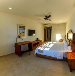 Schlafzimmer mit einem Bett, einem Schreibtisch und einem TV in der Unterkunft Casa Maria Boutique Hotel in San Carlos