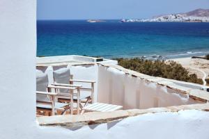 un par de sillas sentadas en el lateral de un edificio con vistas al océano en Naxos Magic Village en Stelida