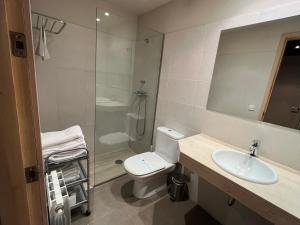 a bathroom with a toilet and a sink and a shower at Can Morera Apartaments a Les Preses in Les Preses